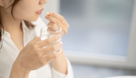 頭痛薬を飲む女性